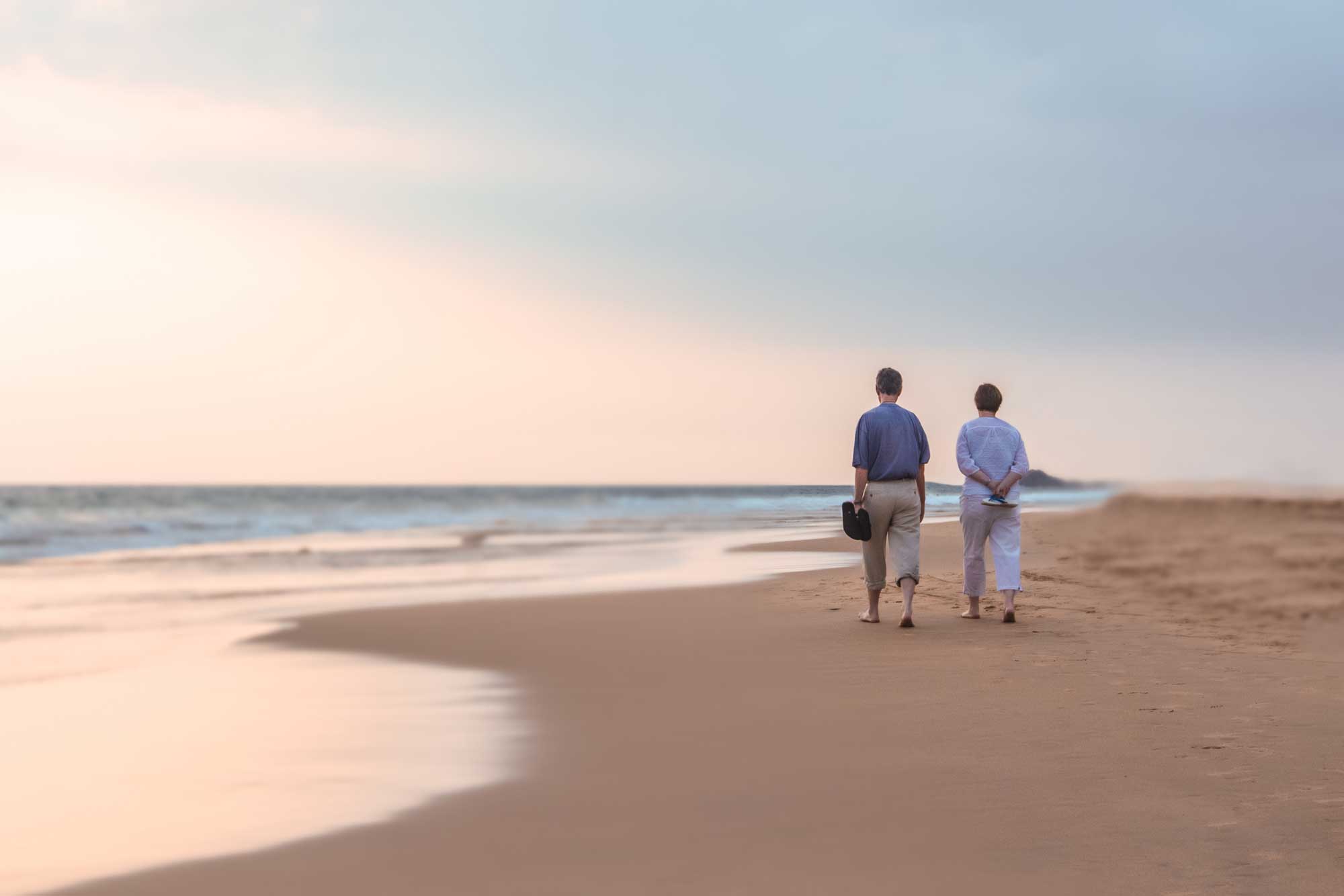 retirees walking on beach